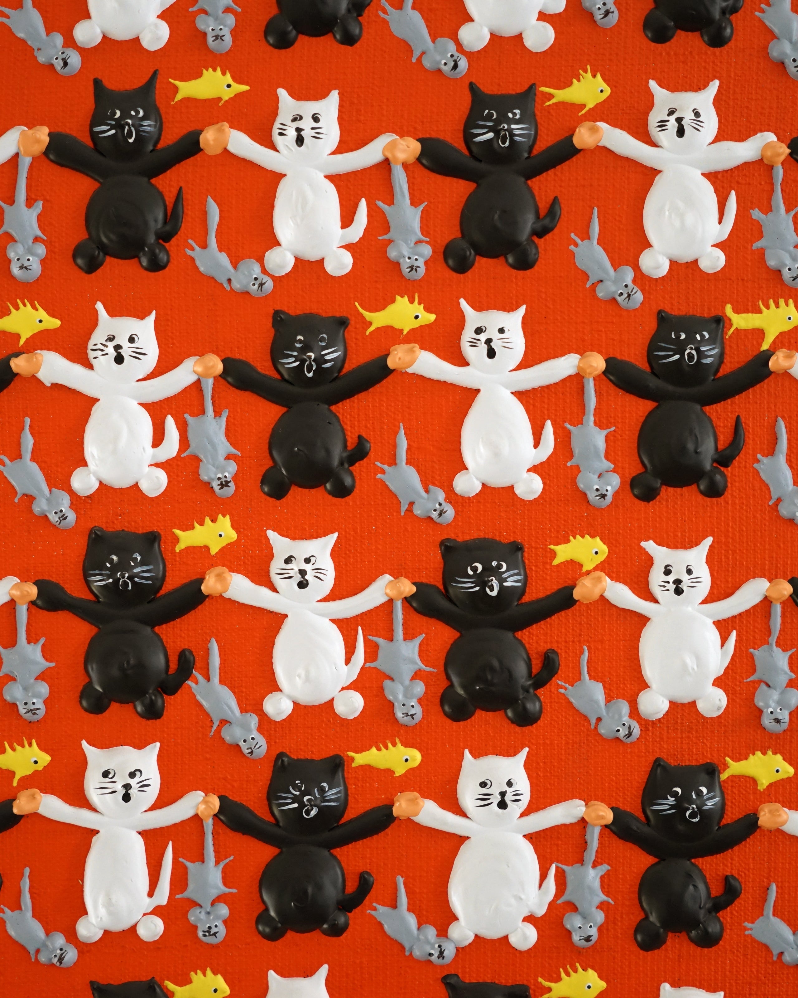 Pattern of black, white, and gray cats holding fish on a red background